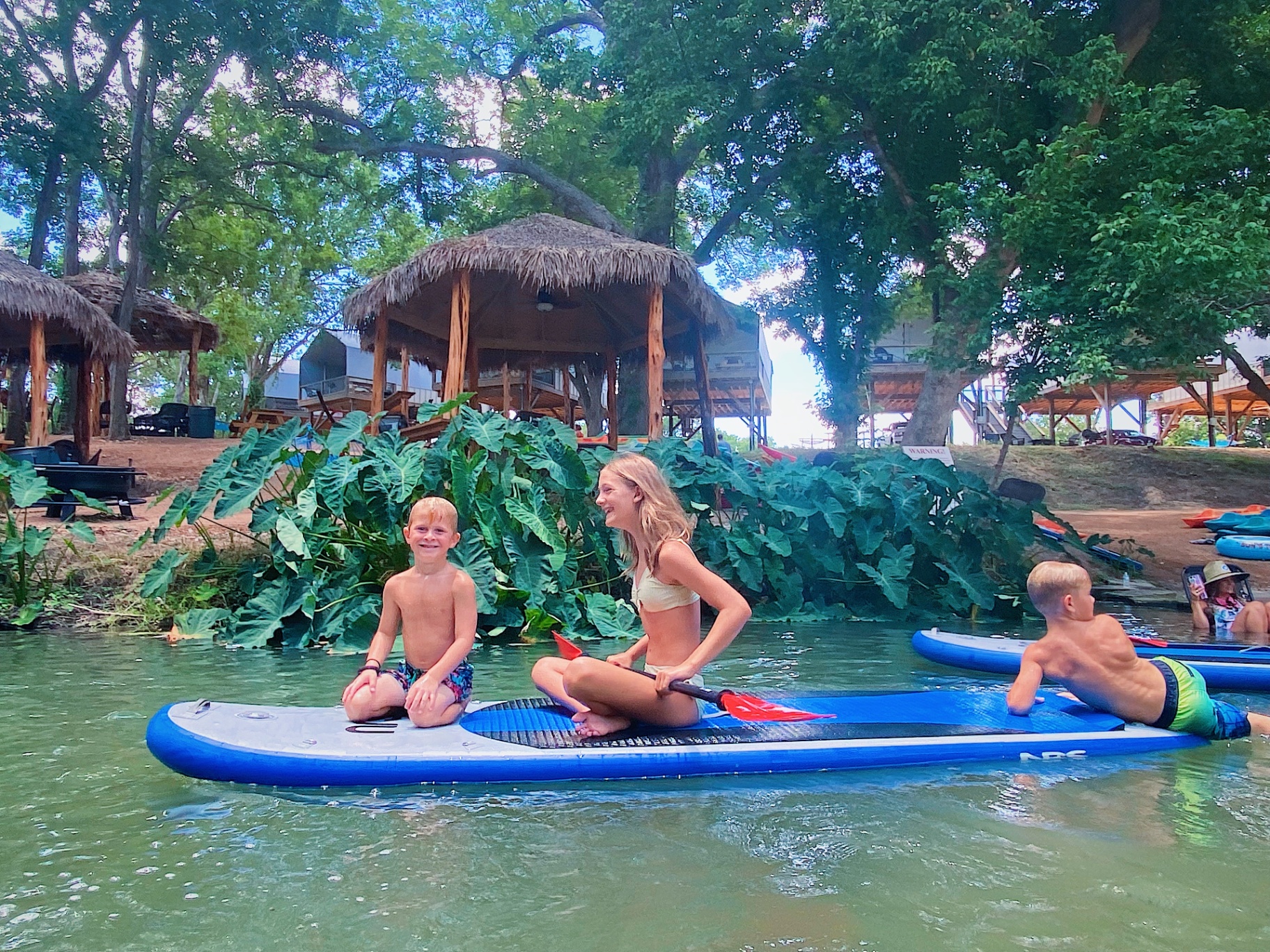 Kids on paddleboard at sunset