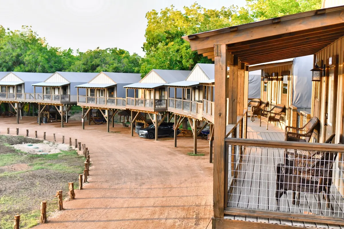 Waterfront glamping cabins row with deck view near San Antonio