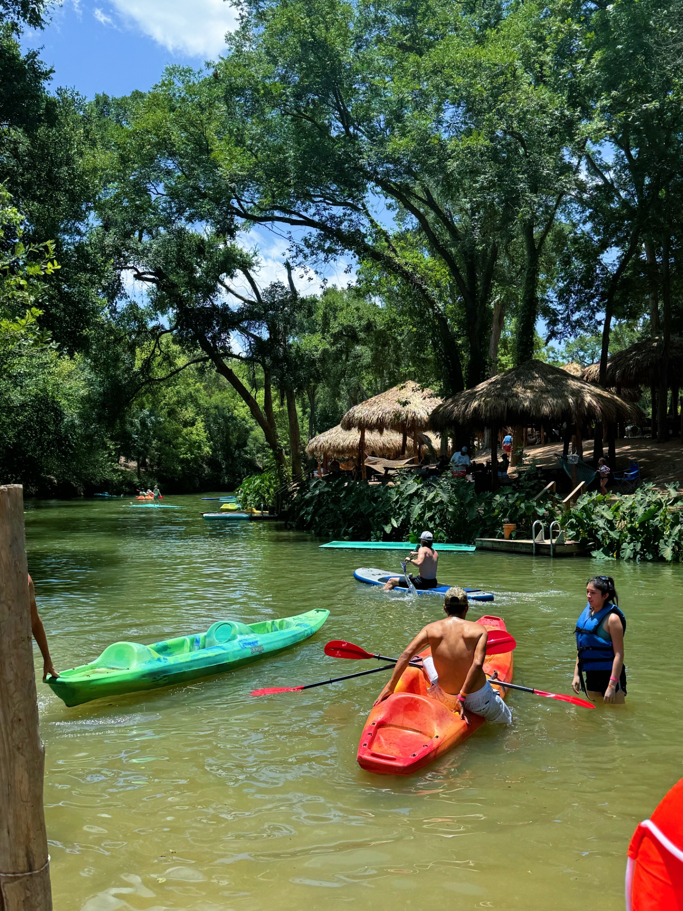 Kayakers paddling near tiki huts