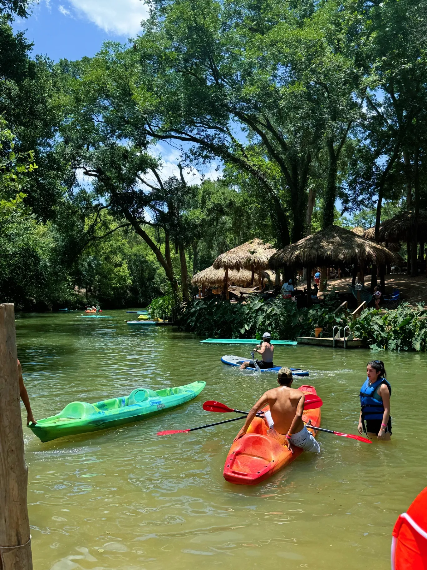 Kayakers paddling near tiki huts
